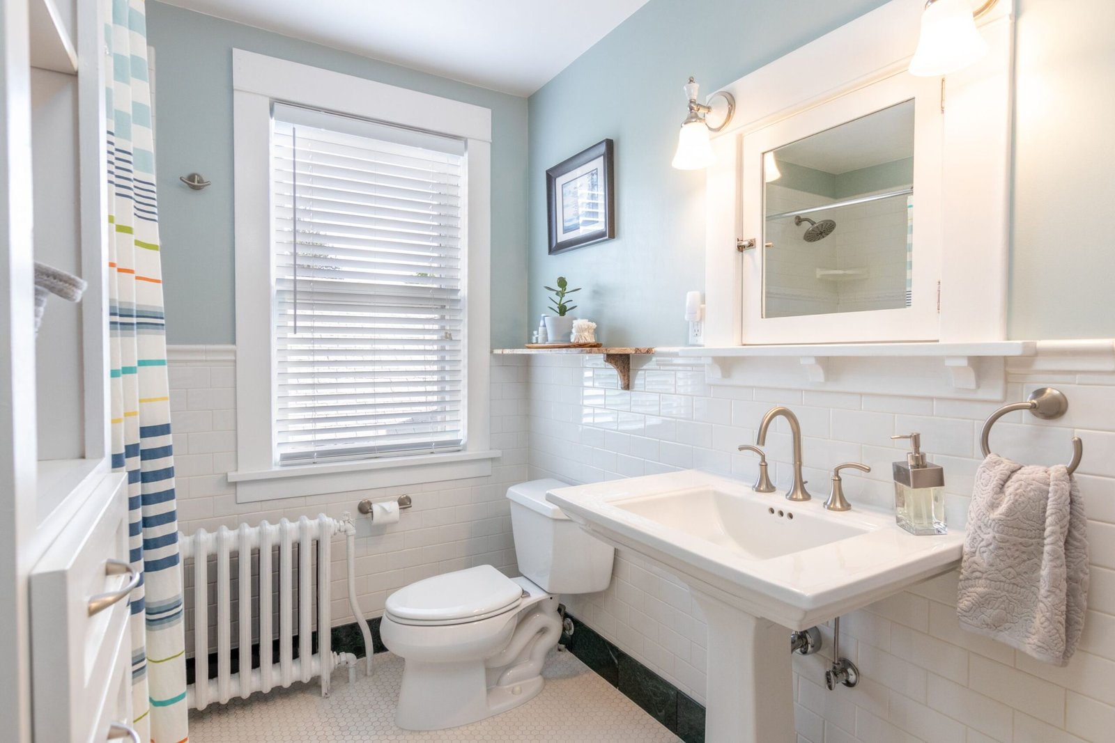 pedestal sink in a small rental bathroom with no under-sink storage